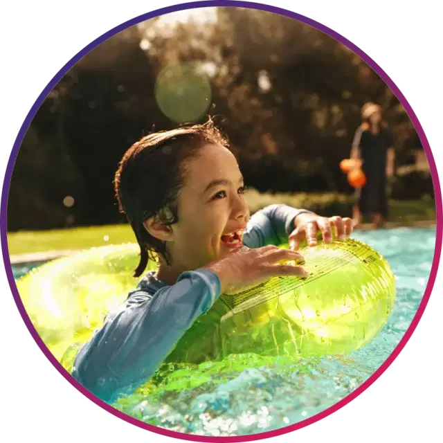 a young child delights in playful splashes, floating happily in an inflatable ring in the pool.