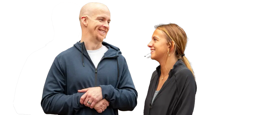 A man and a woman talk, both smiling.