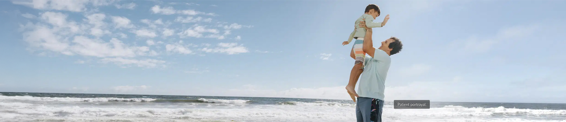 Father lifting up a child above his head in at a beach