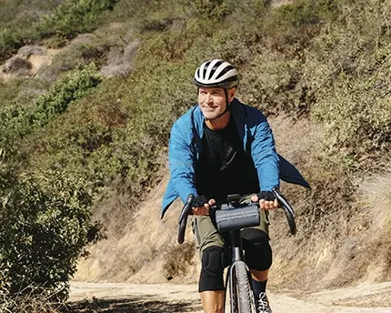 Male cyclist riding down a hill on his bicycle